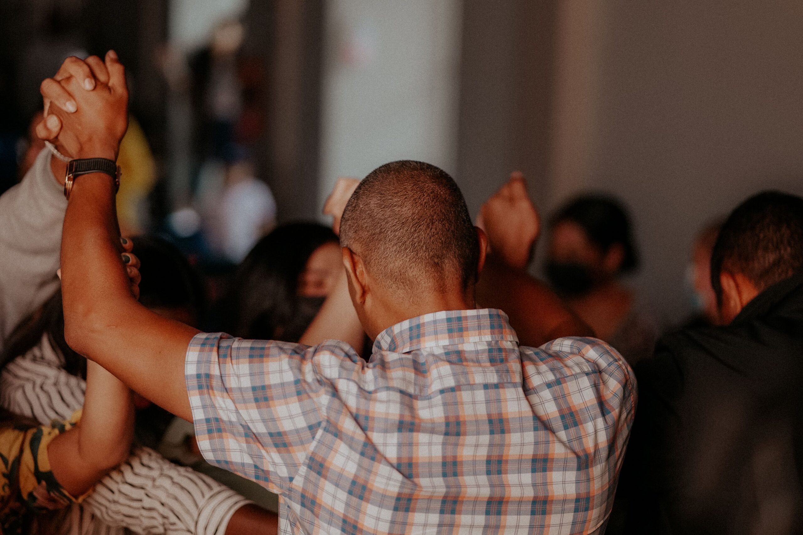 People holding hands with their arms up.